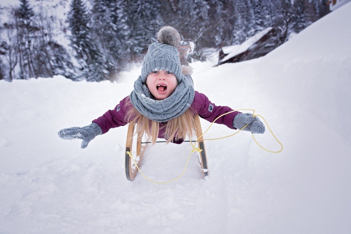 dziewczynka na sankach na śniegu