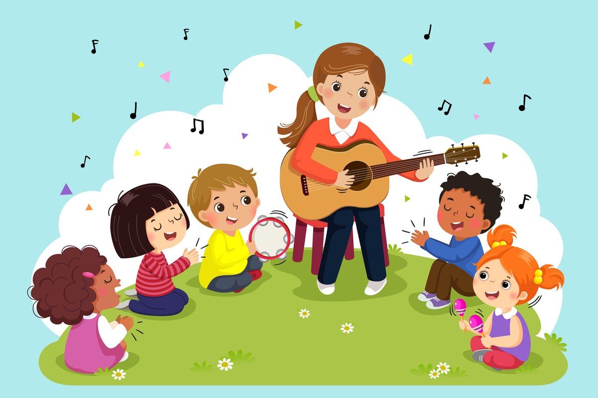 Młoda kobieta gra na gitarze a wokół niej siedzą dzieci i klaszczą lub wystukują rytm
