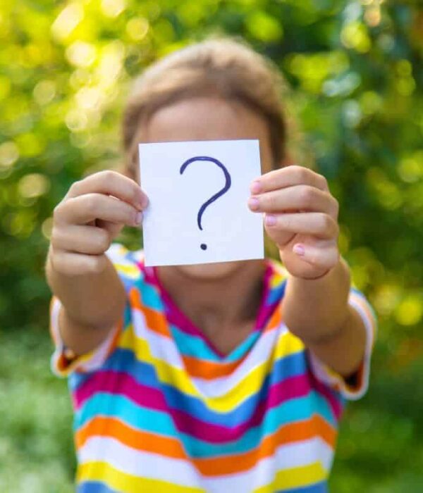 zagadka, dziewczynka pokazuje na kartce znak zapytania
